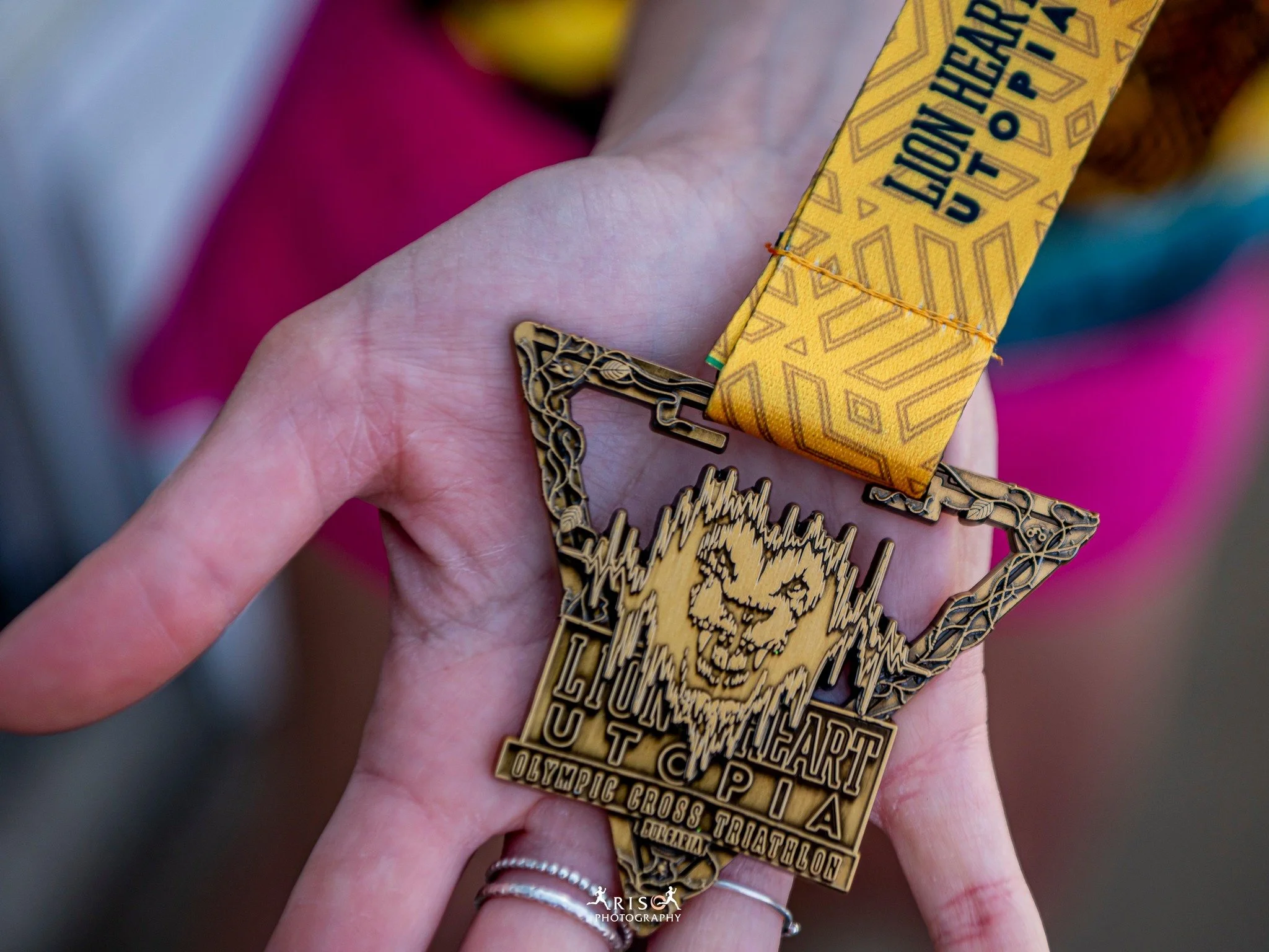 Lion Heart (Лъвско сърце) Utopia medal featuring a triangular shape intertwined with thorny plants and leaves, the logo on display at the center.