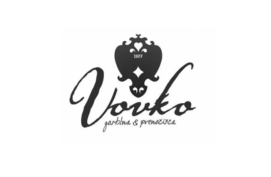 Logo featuring a decorative heart-shaped emblem with the year 1977, the word 'Vovko' in a handwritten script, and an additional phrase in a smaller script.