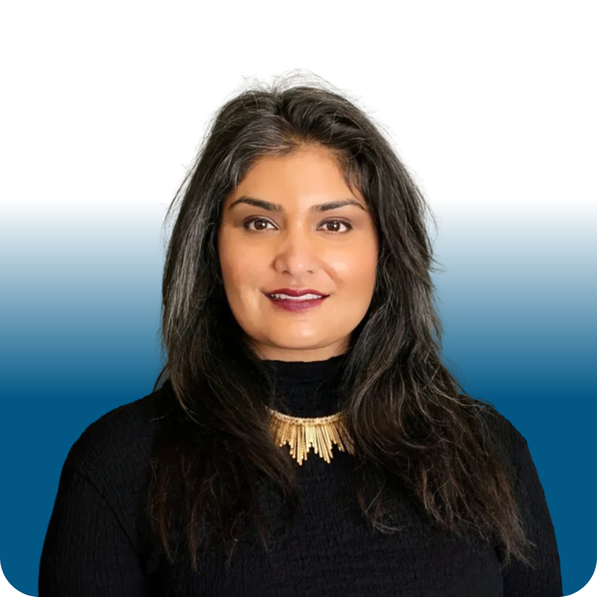 A woman with dark hair, a black turtle neck with a gold necklace and dark rouge lips