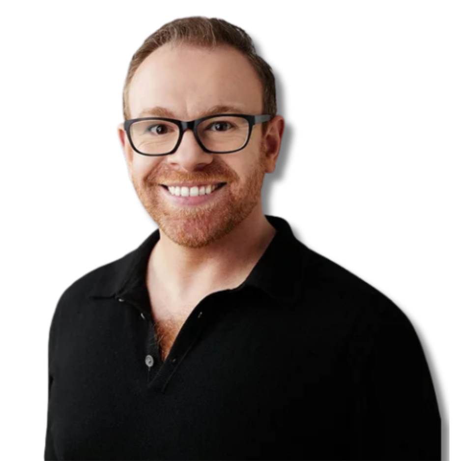 Headshot of a smiling man with glasses, short reddish-brown hair, and a trimmed beard, wearing a black collared shirt, against a gray background.