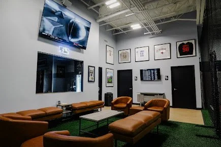 Clubhouse seating and player jerseys inside Compete BP in Dallas