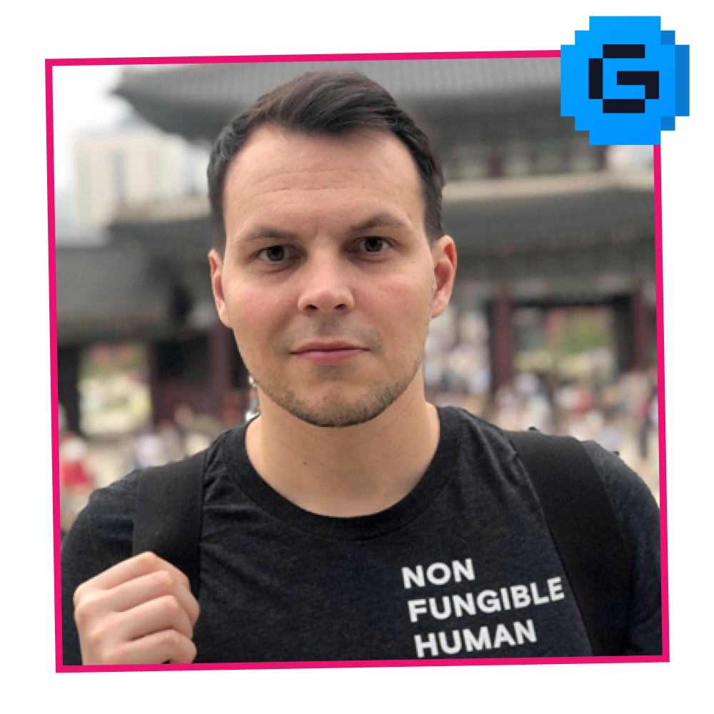 Young man with short dark hair, wearing a black T-shirt with white text 'NON FUNGIBLE HUMAN' and carrying a backpack, standing outdoors in front of a traditional Asian-style building.