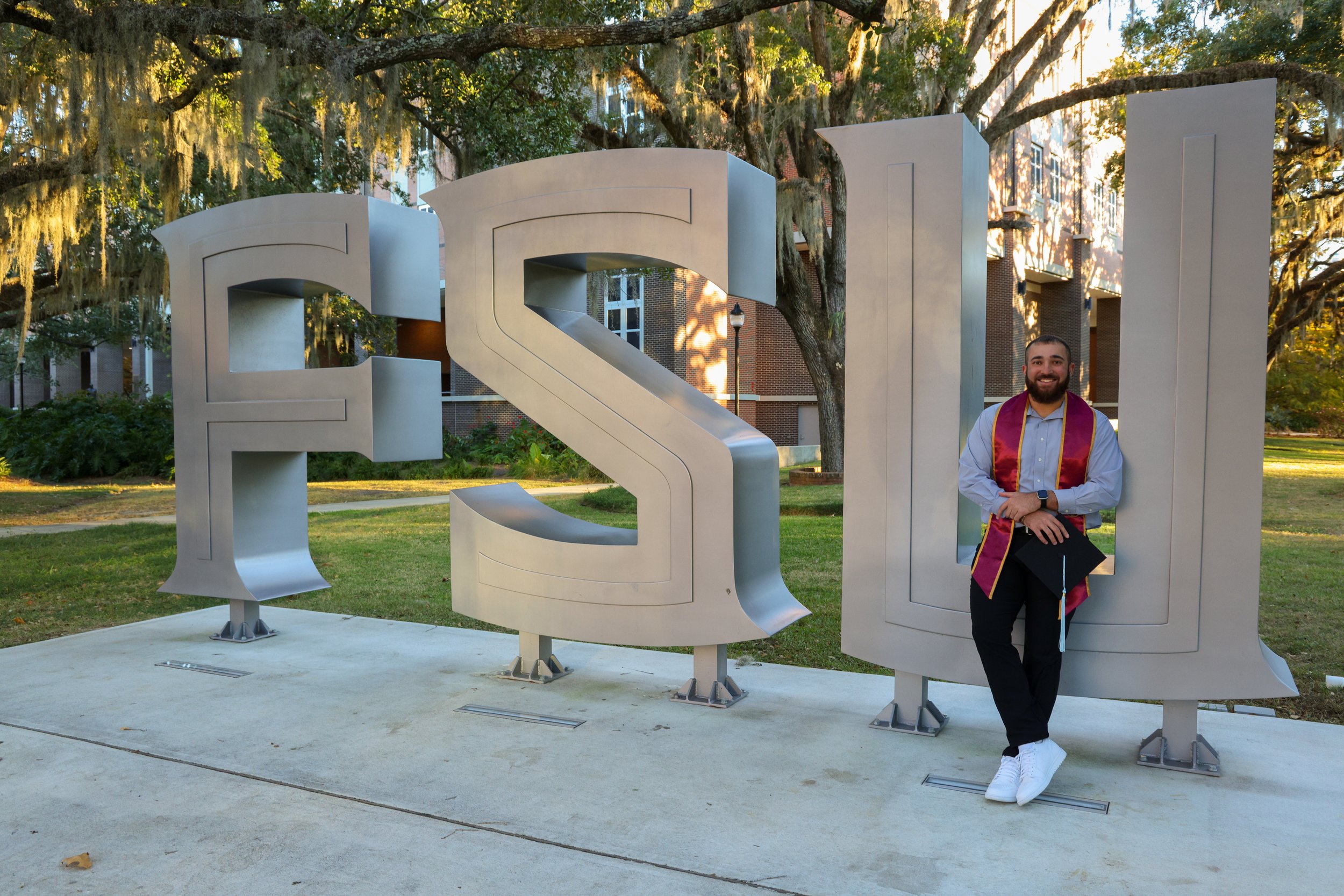 FSU graduate posing at the Florida State University letters during a graduation photo session