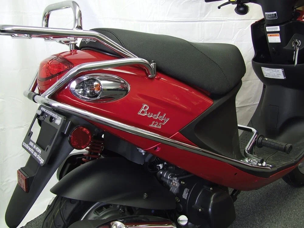 Red Buddy 125 scooter with black seat and chrome handlebar guard.