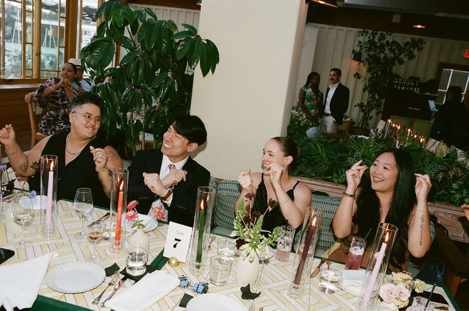 People seated at a decorated table celebrating and smiling during a social event or dinner.