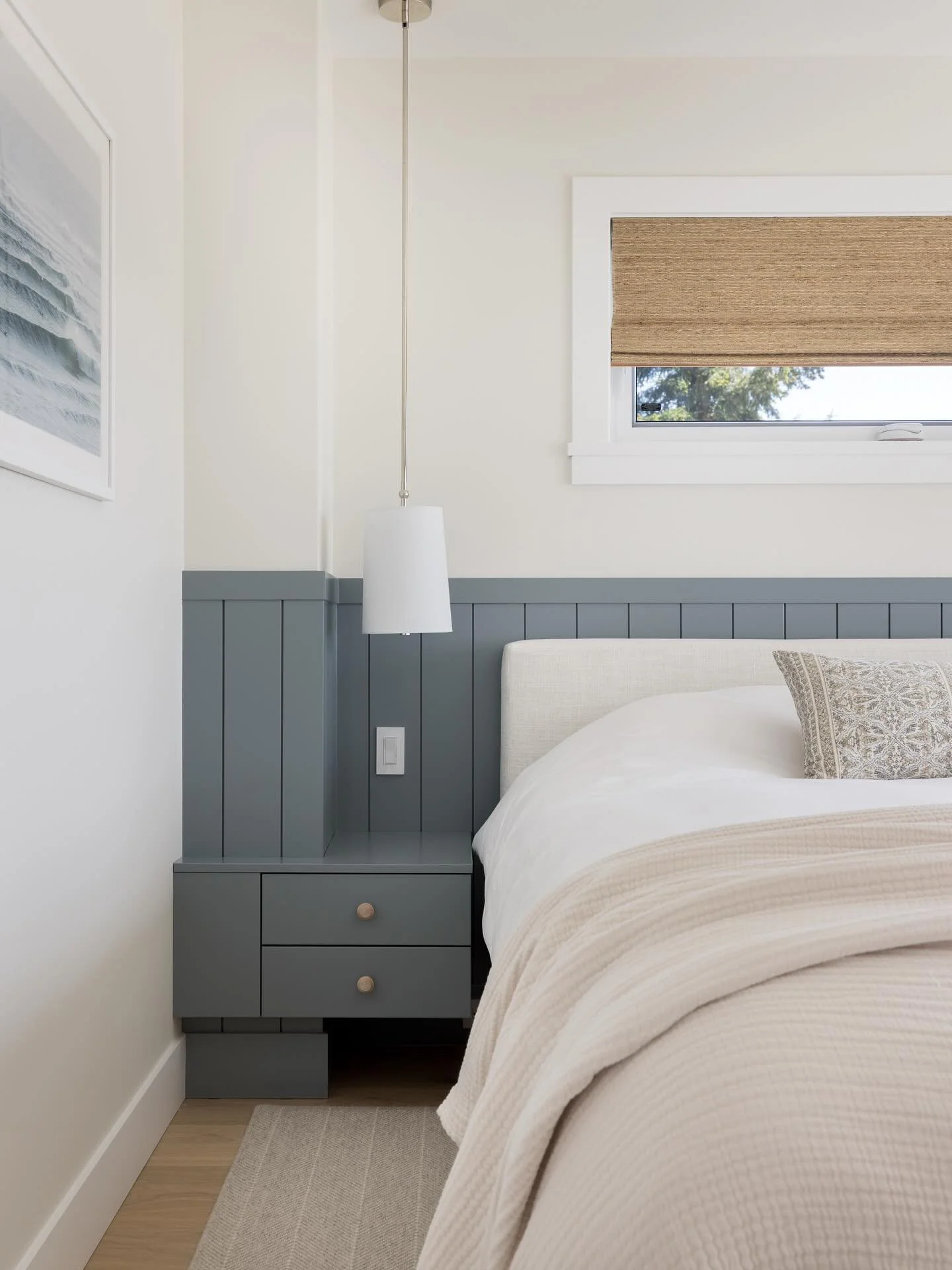 Renovations always come with unique challenges. 

A chase in the corner of this bedroom limited space for a nightstand and could have thrown off the symmetry of the small room. Instead we wrapped it in a continuous headboard detail with integrated be