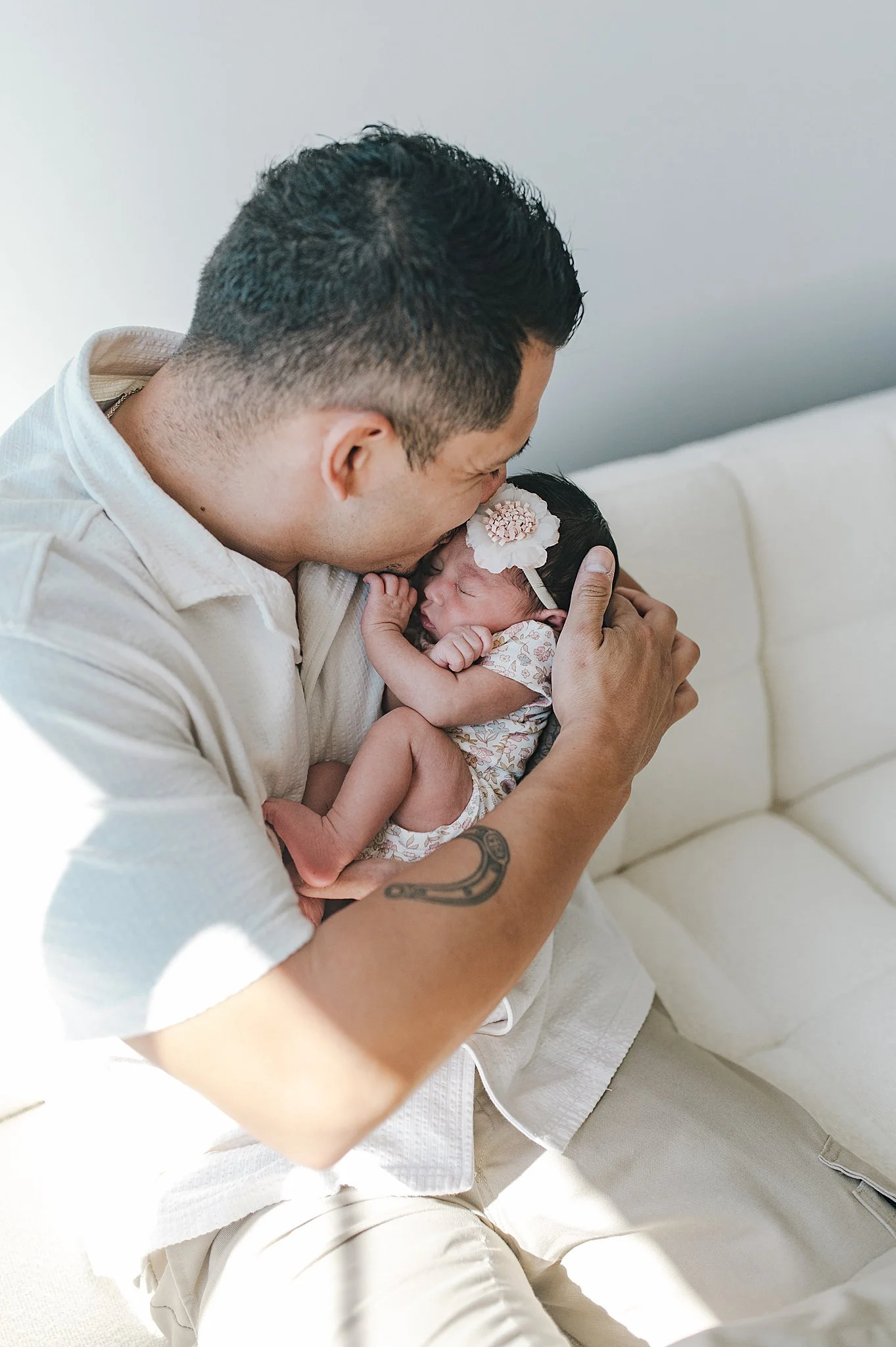 Dad snuggling his newborn baby girl during a studio newborn session in Las Vegas.