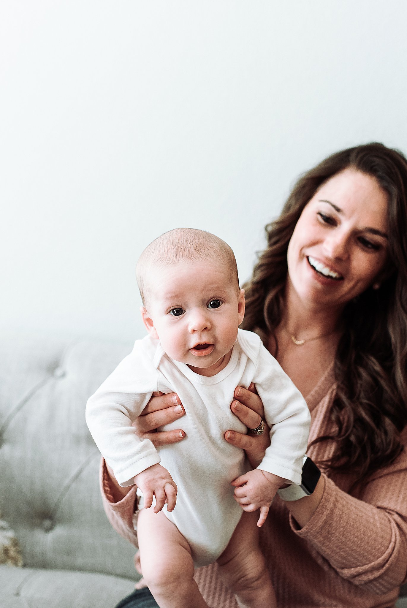 A mom and her baby laughing and smiling during their newborn session at their home in Summerlin, Las Vegas.