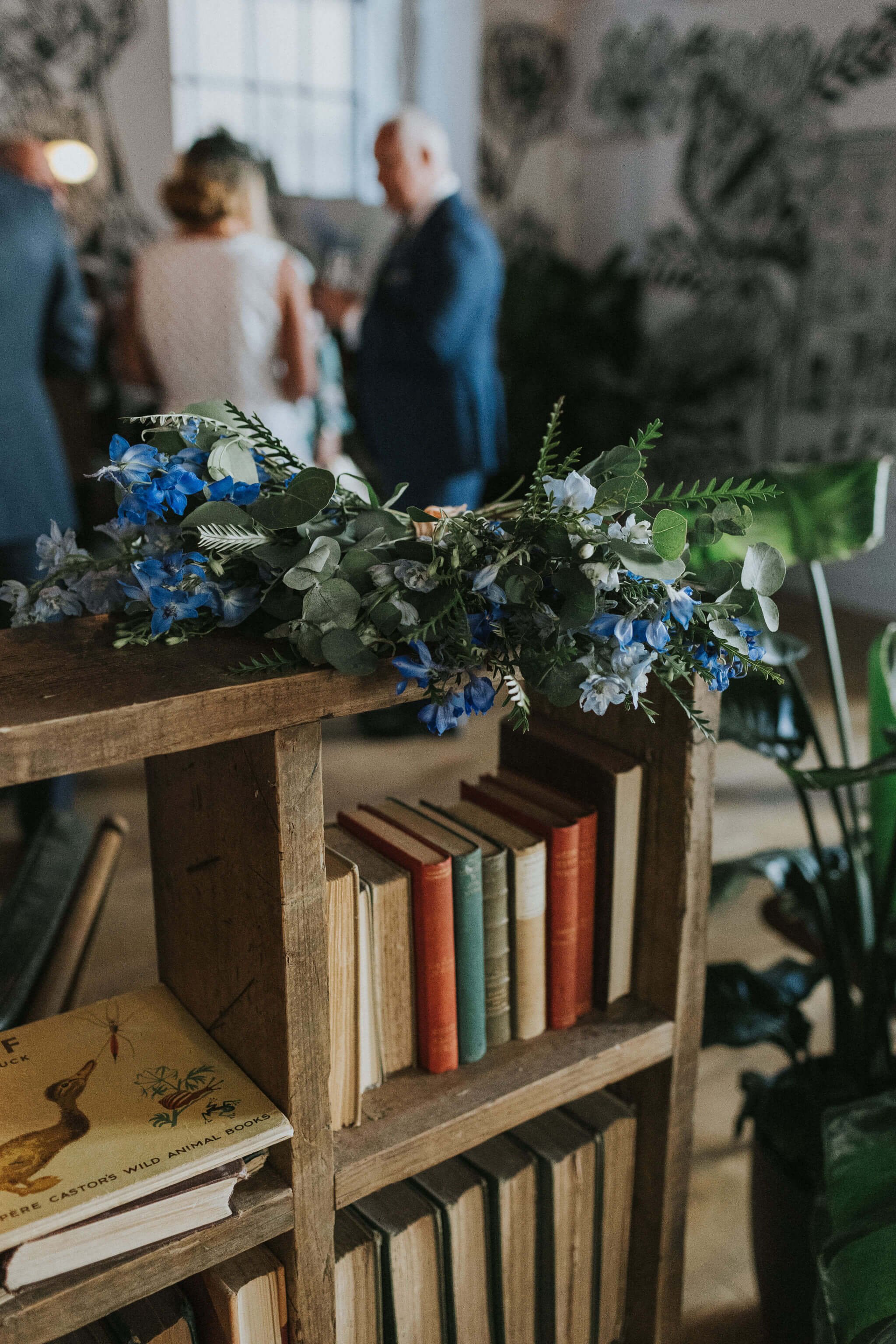 Flowers-on-bookshelf-during-wedding-cocktail.jpg