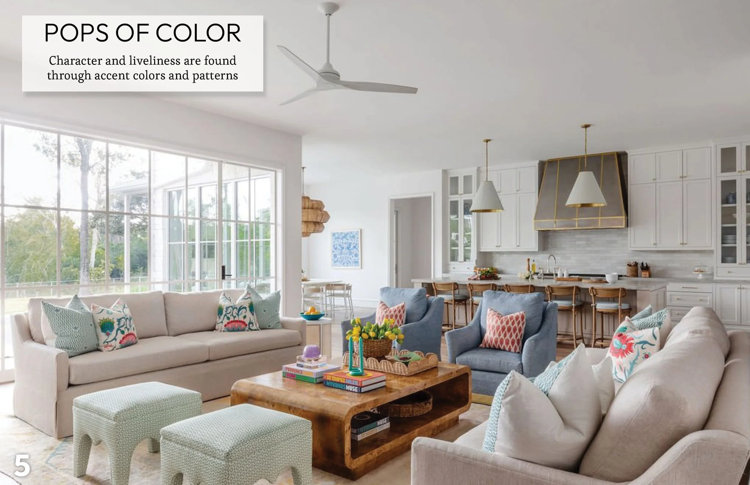 Open concept living room with expansive windows, neutral furnishings, and colorful accent pillows that create visual continuity throughout the home.