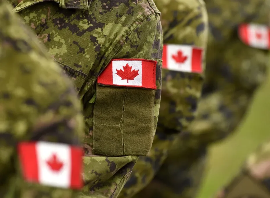Close-up of military uniforms with Canadian flags on their sleeves.