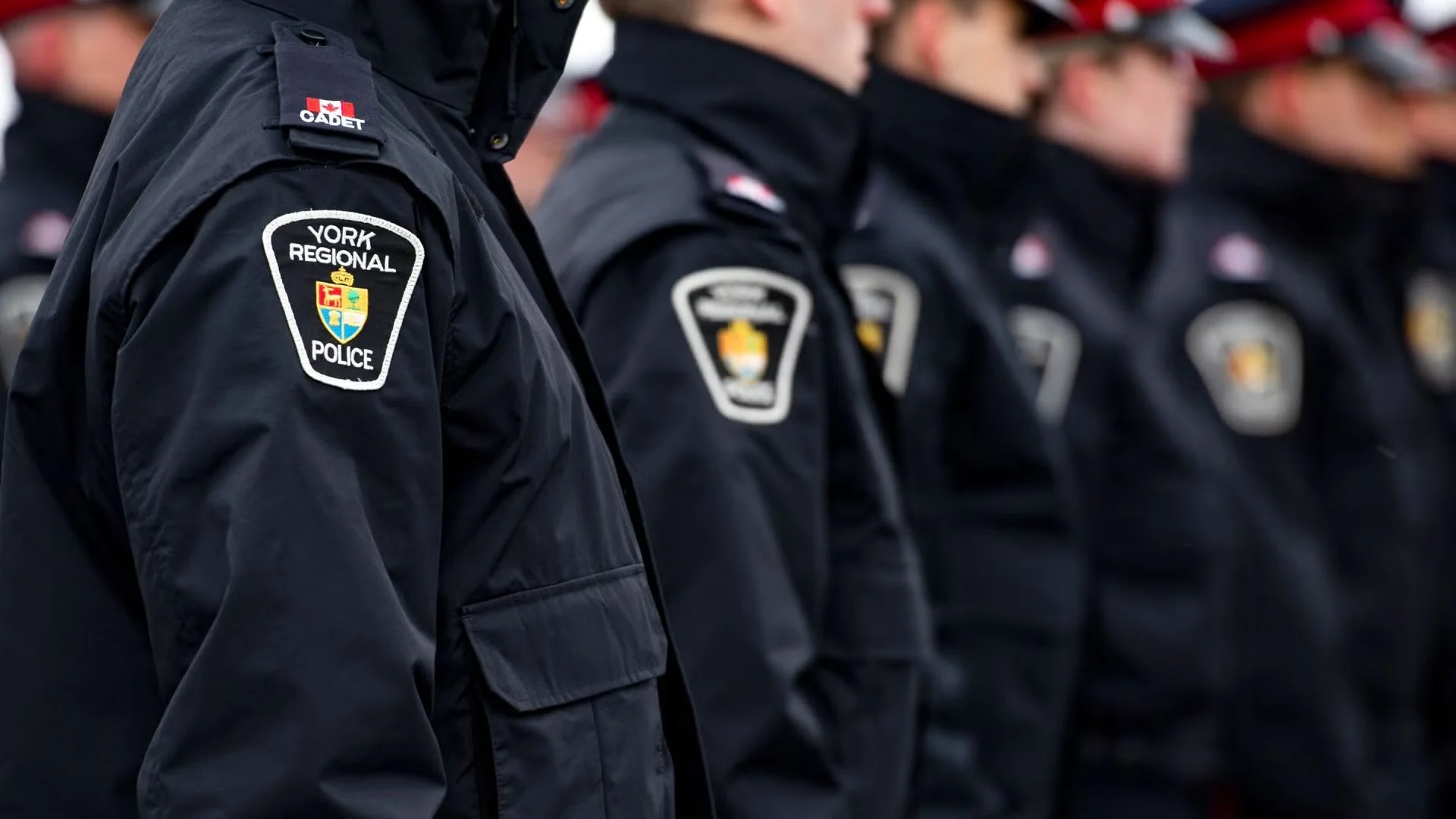 Line of police officers in uniform standing at attention, with shoulder patches indicating York Regional Police.