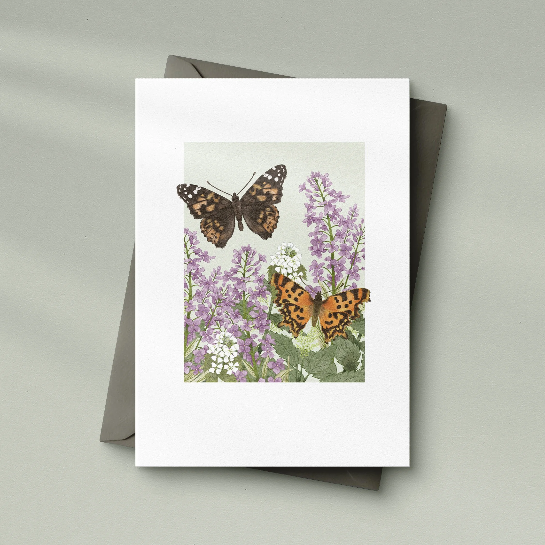 Butterflies and flowers illustrated A6 card. Sitting on a grey envelope.