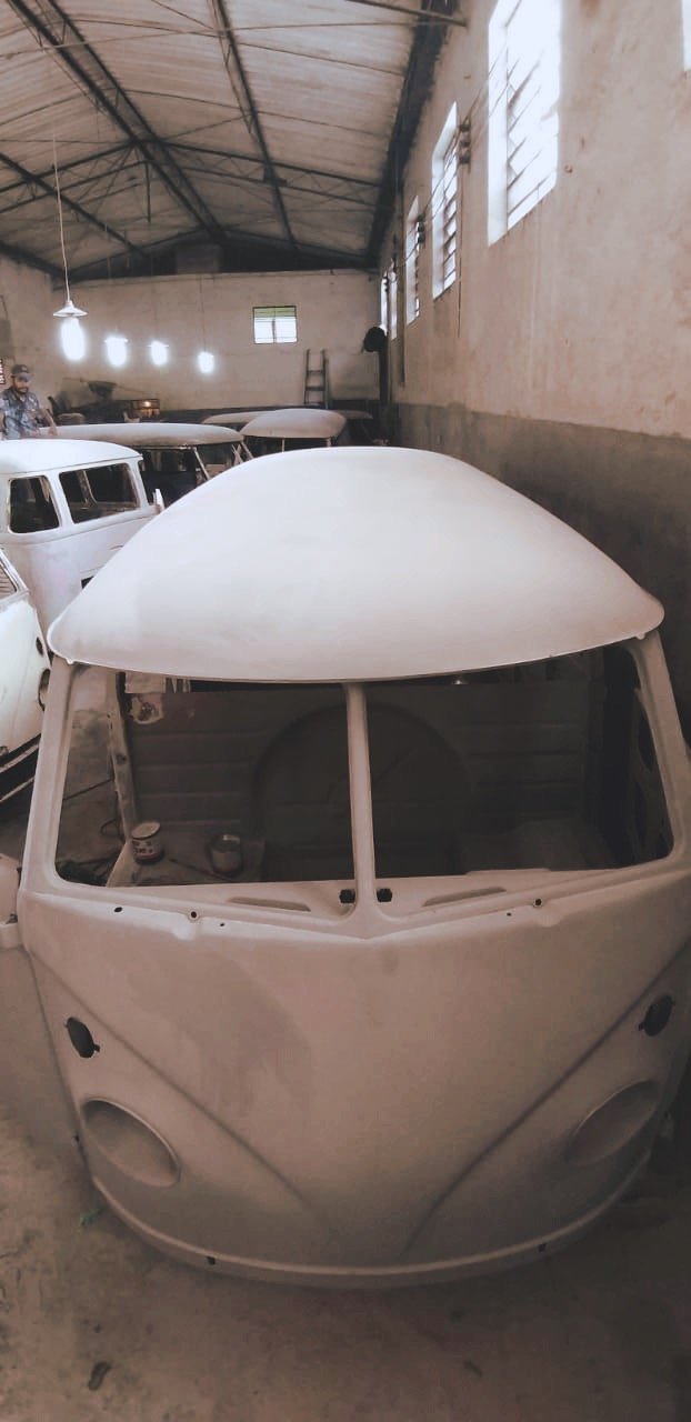 Volkswagen vans being restored in a workshop.
