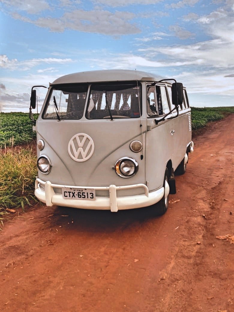 Vintage Volkswagen van on a dirt road with open landscape and blue sky