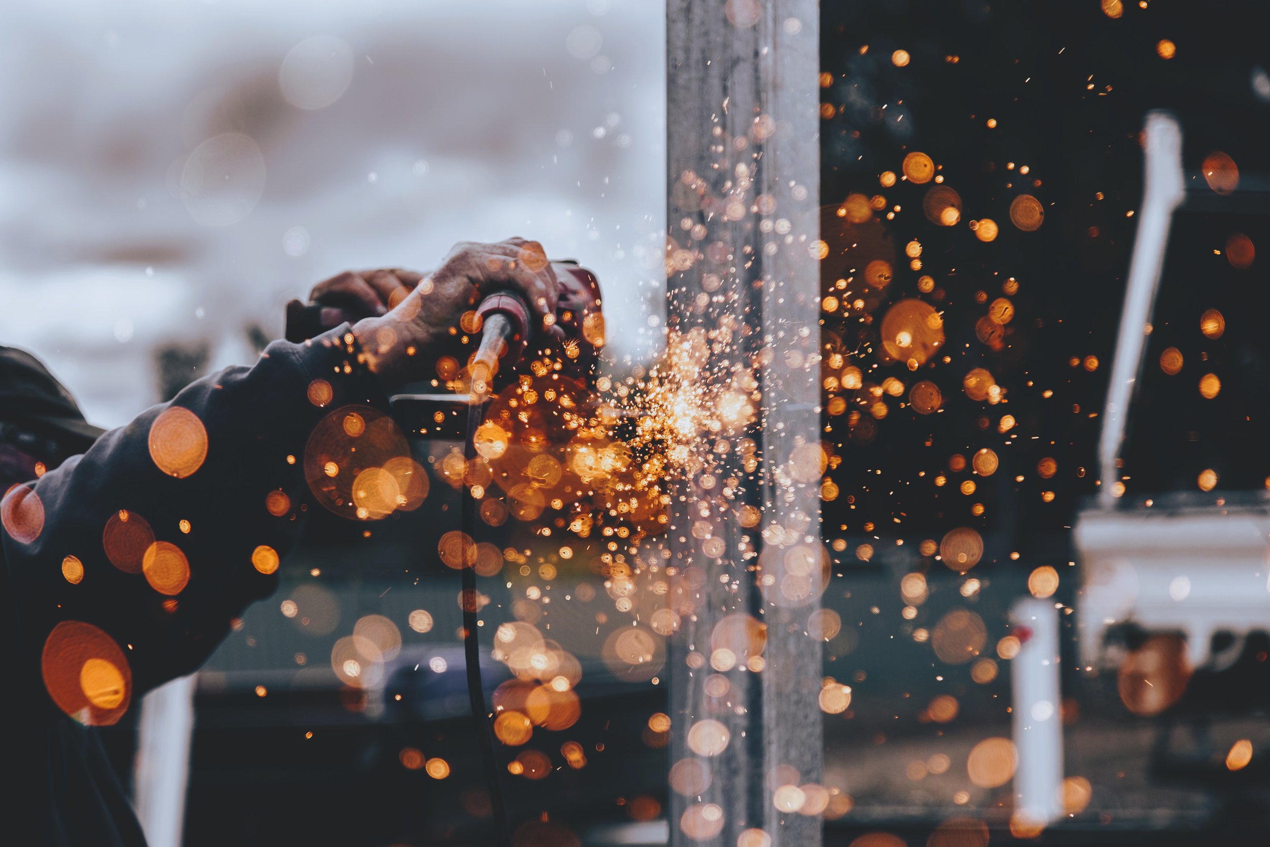 Person using power tool creating bright sparks
