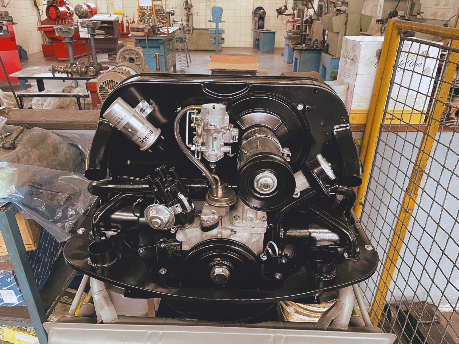 Volkswagen Beetle engine in workshop, displayed on stand.