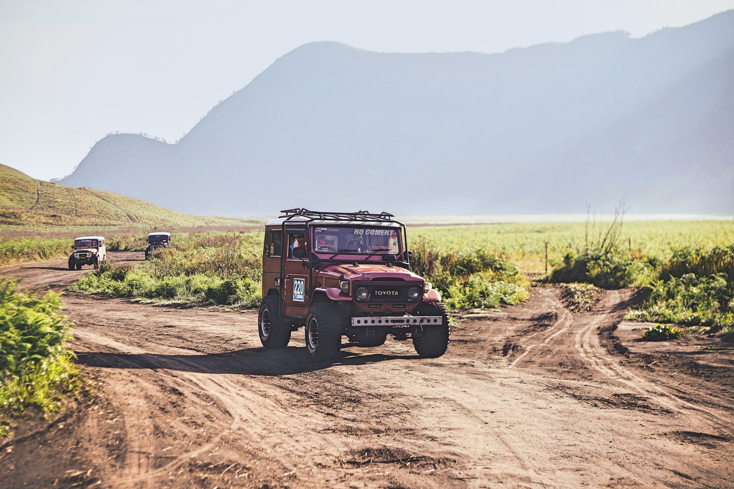 Toyota Land Cruiser on dirt road with mountains