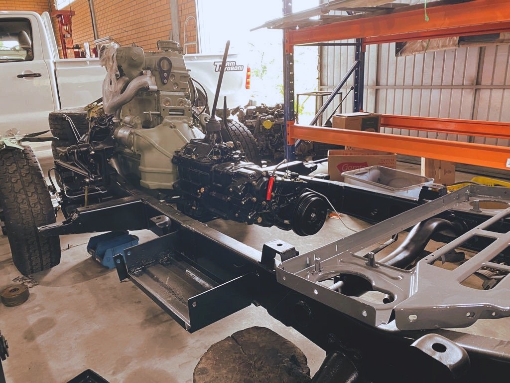 Vehicle chassis with engine and transmission assembly in a workshop