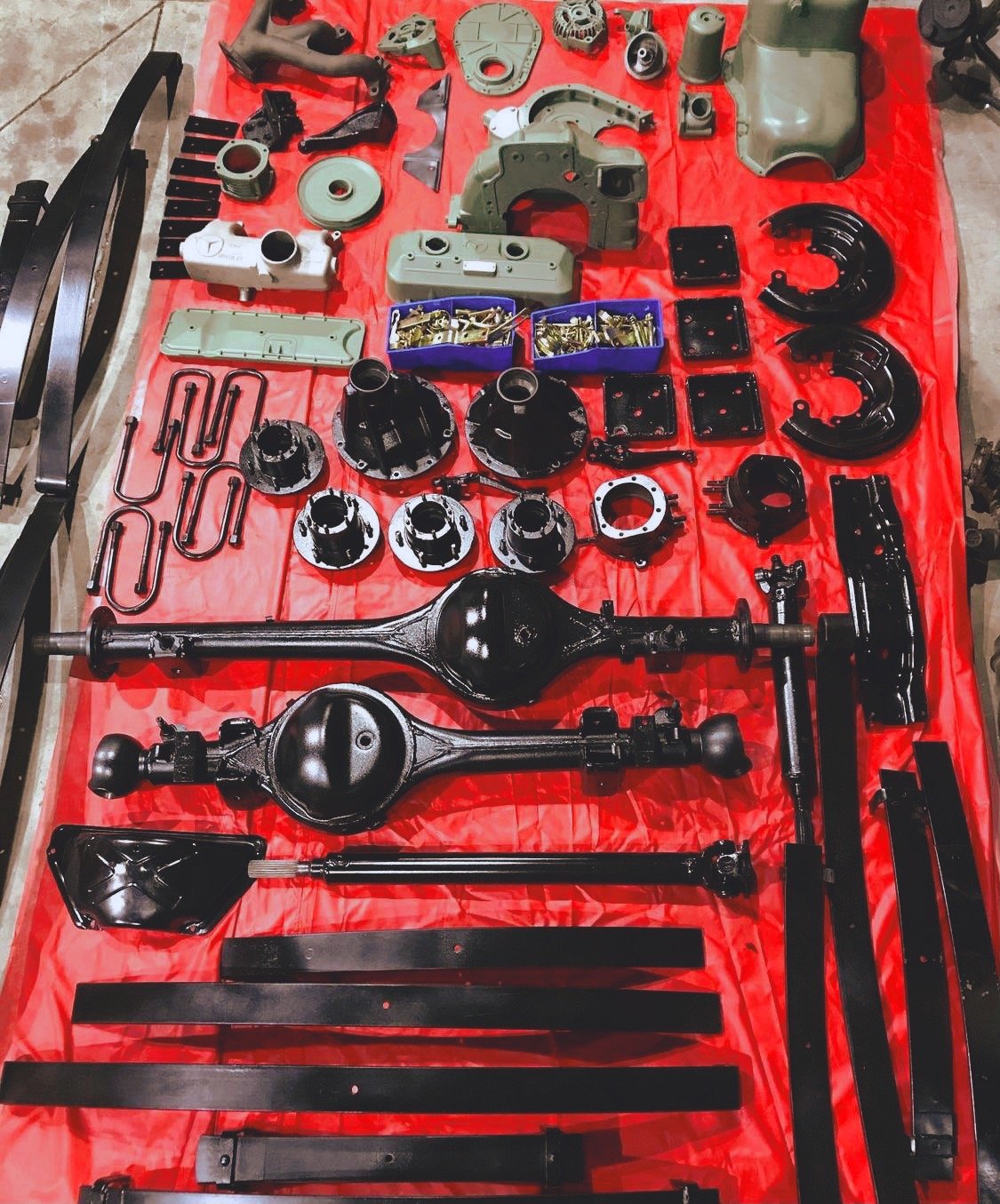 Assorted mechanical parts laid out on red surface