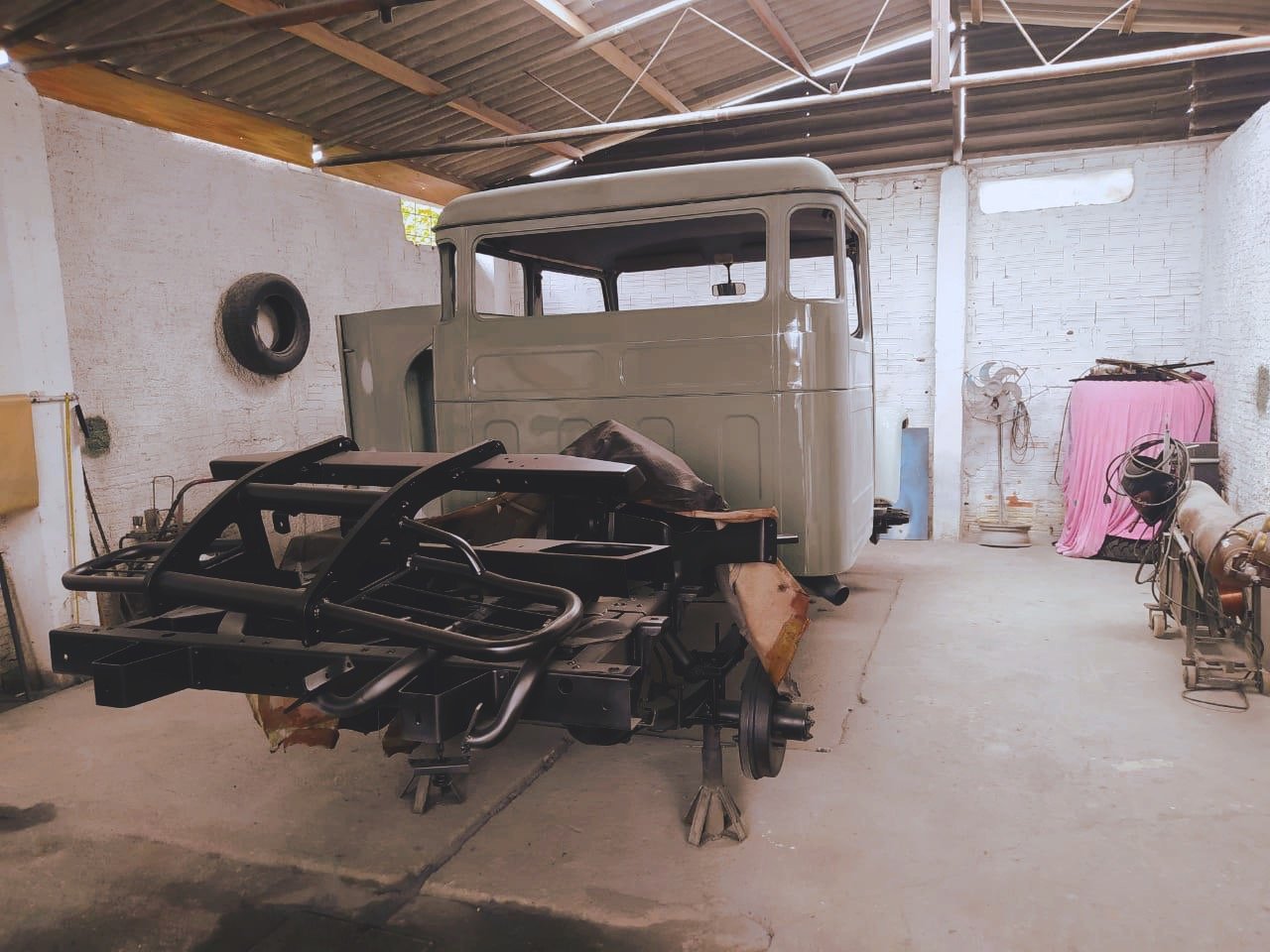 Truck chassis and cab in a workshop with tools and equipment