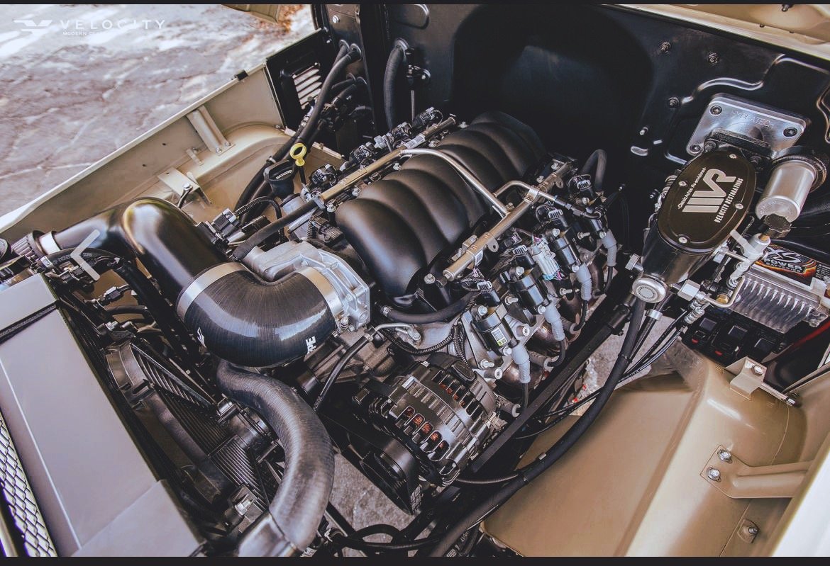 Modern car engine with performance upgrades, including an air intake system and various components in an engine bay.