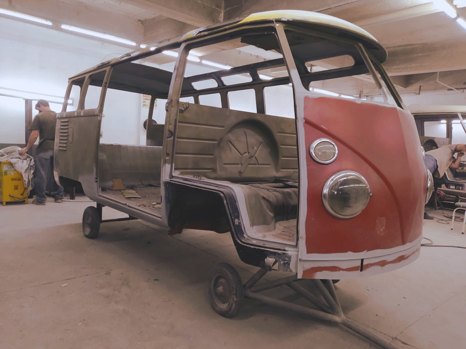 Disassembled vintage Volkswagen bus being restored in a workshop.