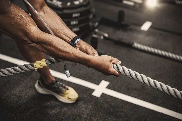 Athlet beim HYROX Sled Pull – kraftvolles Ziehen am Seil als Teil des funktionellen Kraft- und Ausdauertrainings.