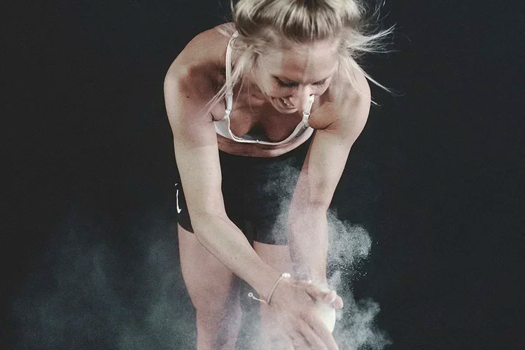 Athletin bereitet sich mit Magnesia auf das Krafttraining im Coach Matzen Gym vor.