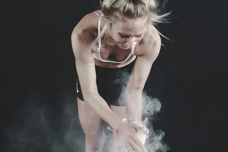 Athletin bereitet sich mit Magnesia auf das Krafttraining im Coach Matzen Gym vor.