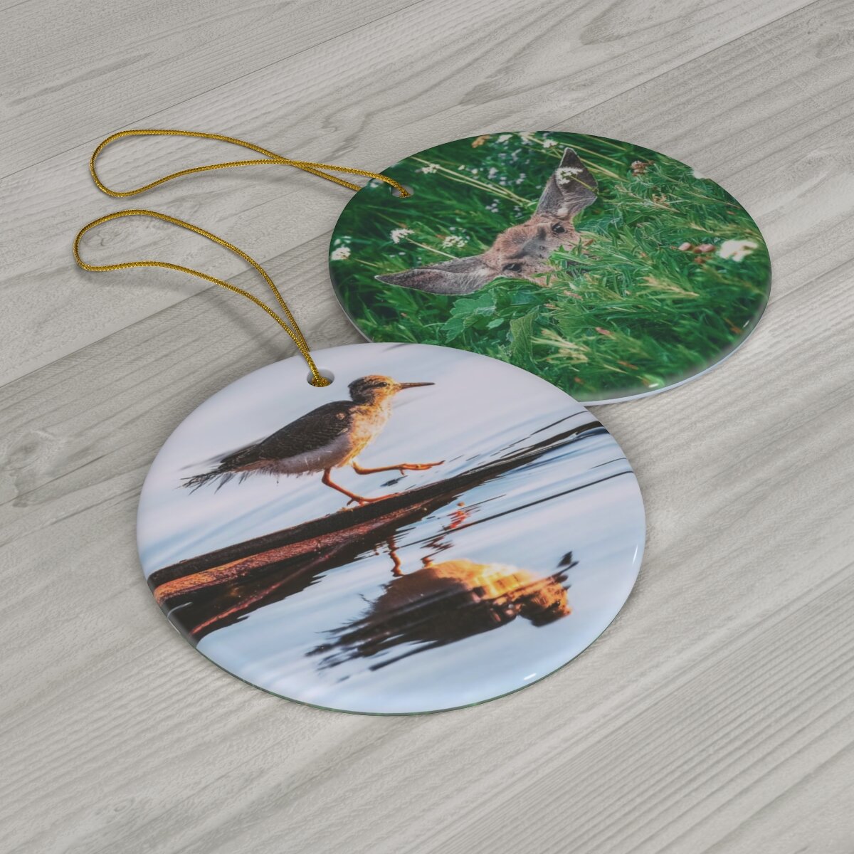 Front and back view of a high-quality porcelain ornament, displaying a serene Sandpiper on the front and a young deer in the wilderness on the back.