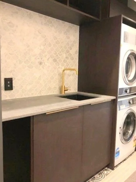 Black laundry with stacked washer and dryer