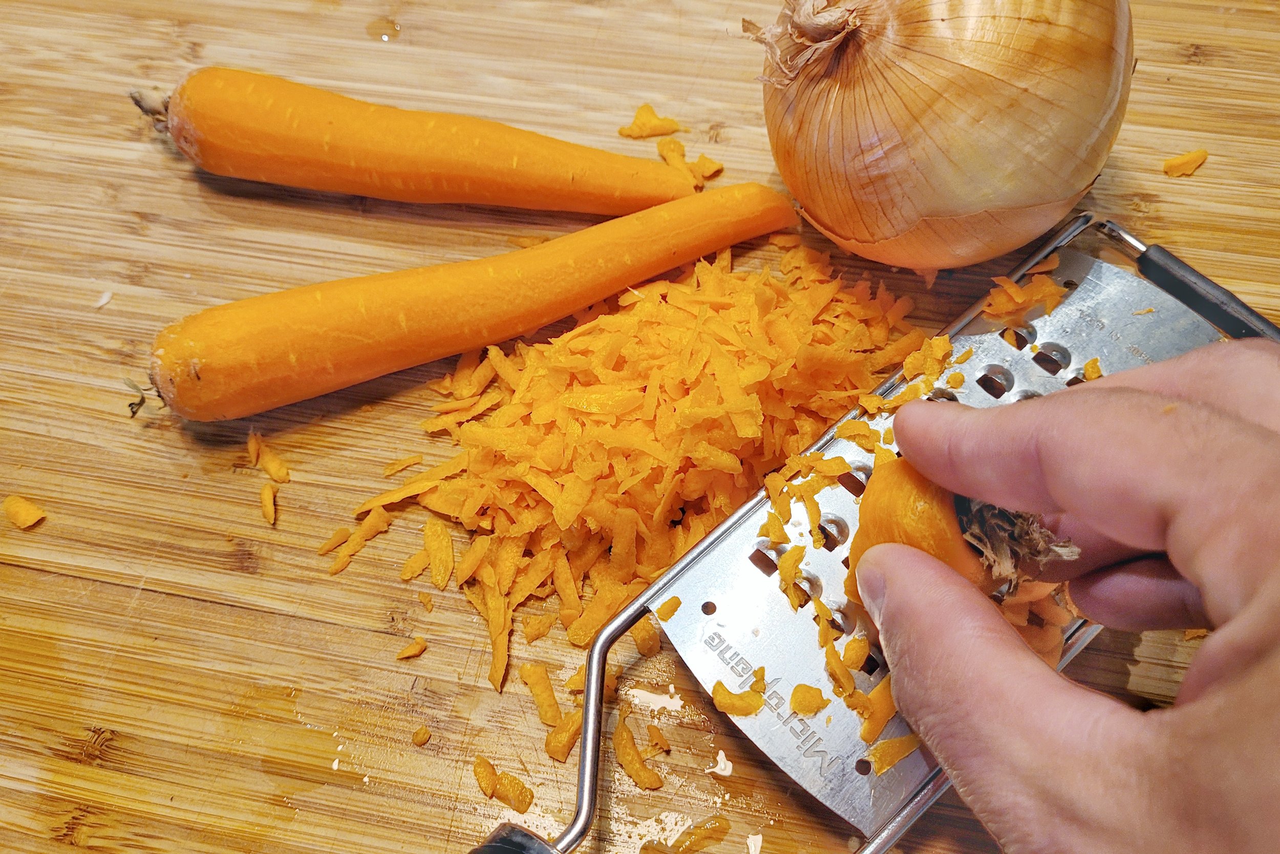 Grate carrots and onion.