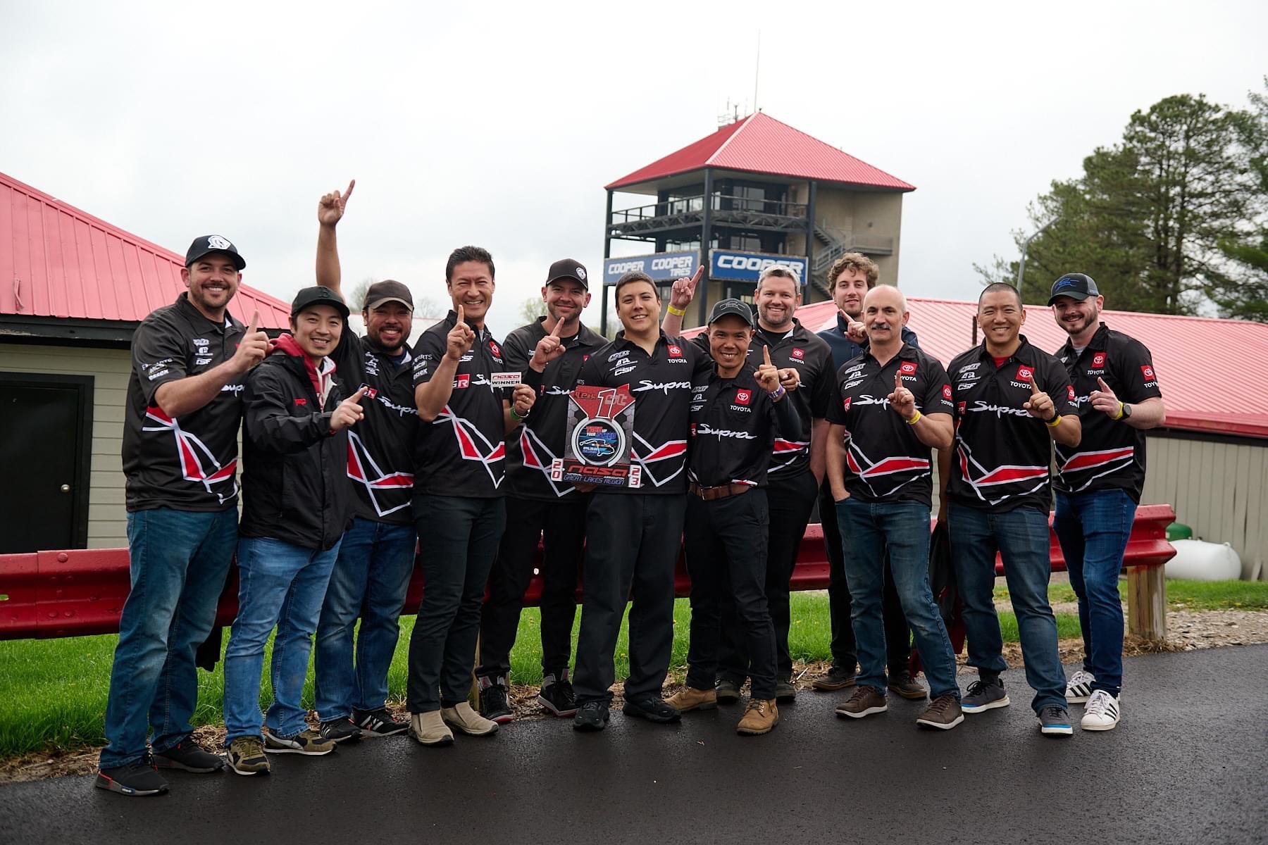 Toyota R&D Racing team posing with a trophy at Mid-Ohio after winning the four-hour NASA TREC endurance race.