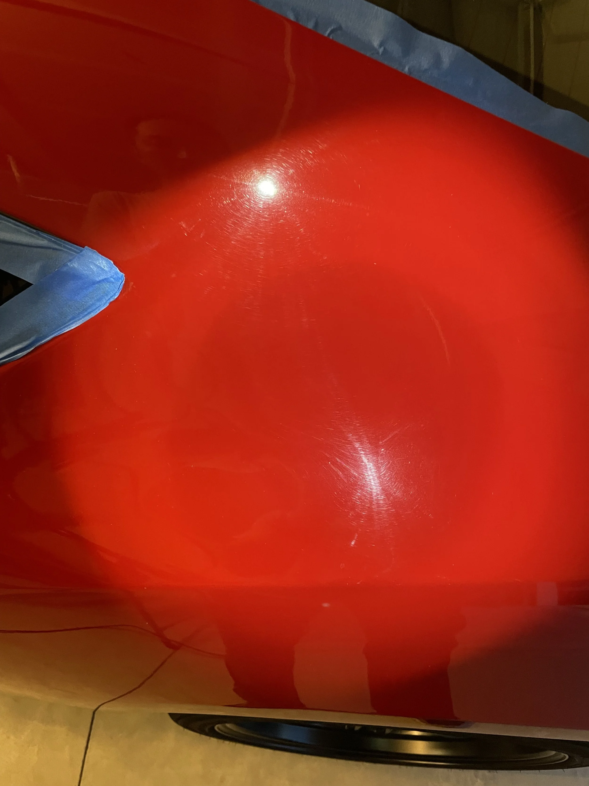 Swirl marks and fine scratches in red FR-S paint under a bright inspection light.