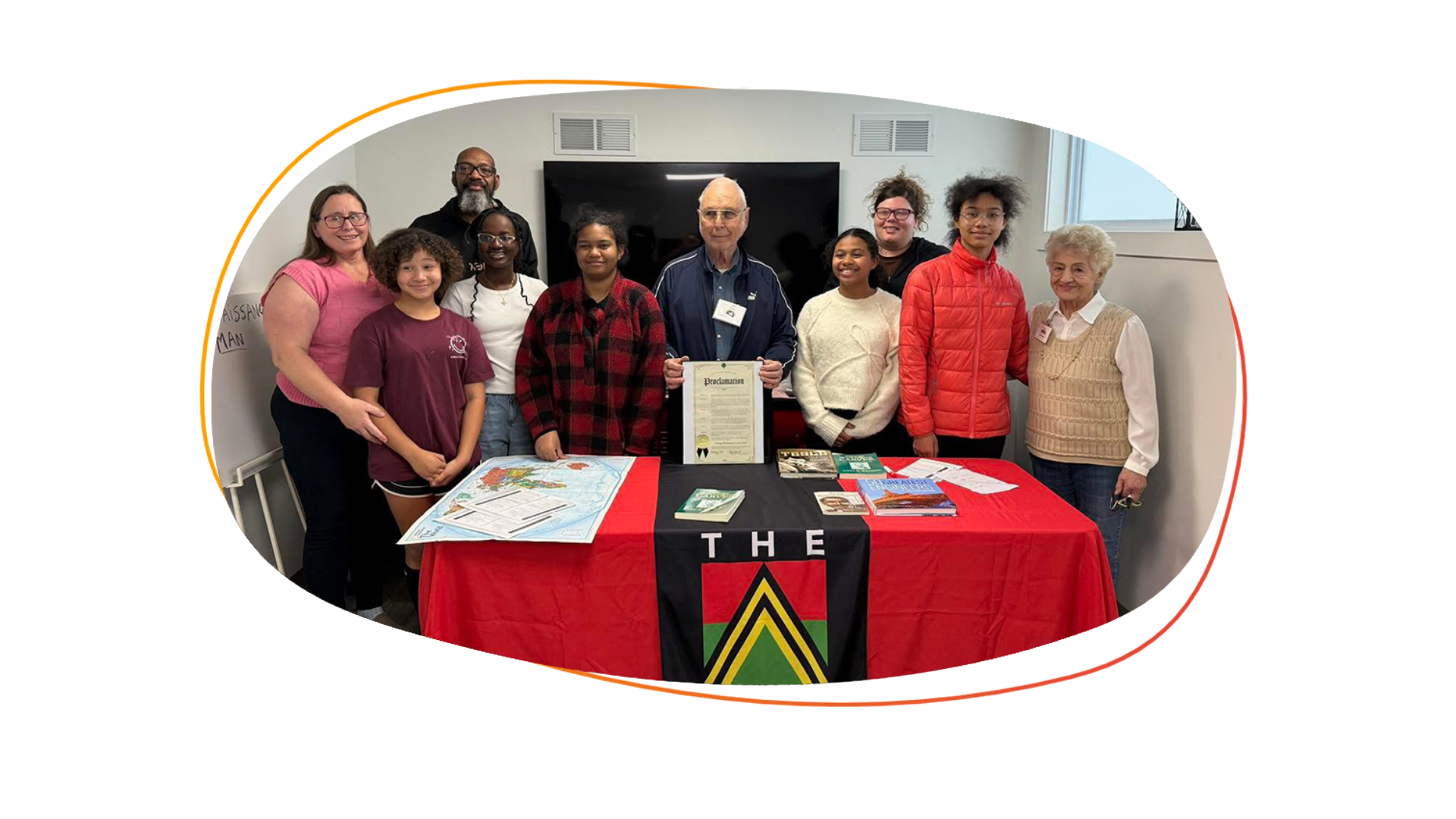 group of middle school students and a few adults pose for a photo at a presentation  about George Washington Carver where SPS was given the proclamation for their building.