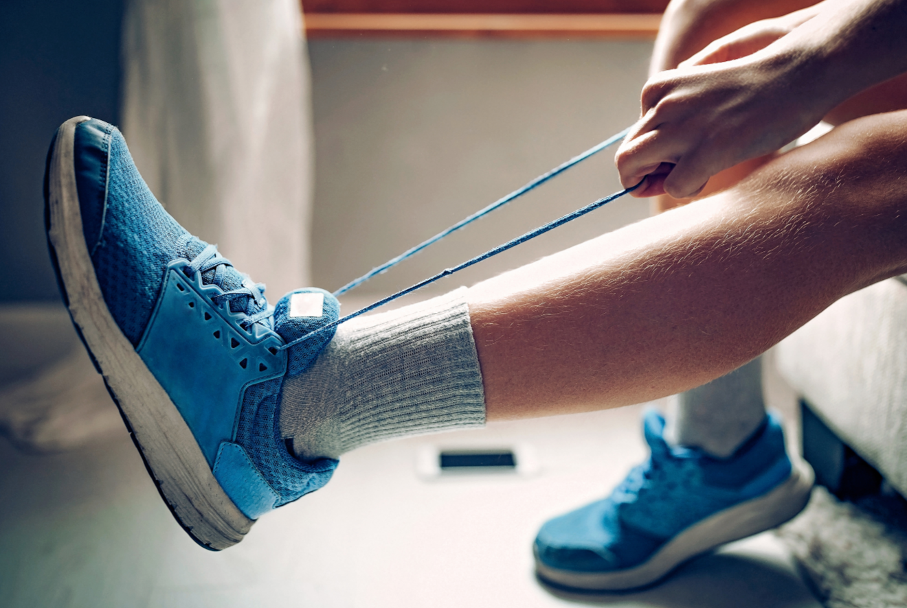 photo of kid pulling on laces of blue tennis shoe, getting ready to tie the laces. copyright eclipse_images from Getty Images Signature by canva.com