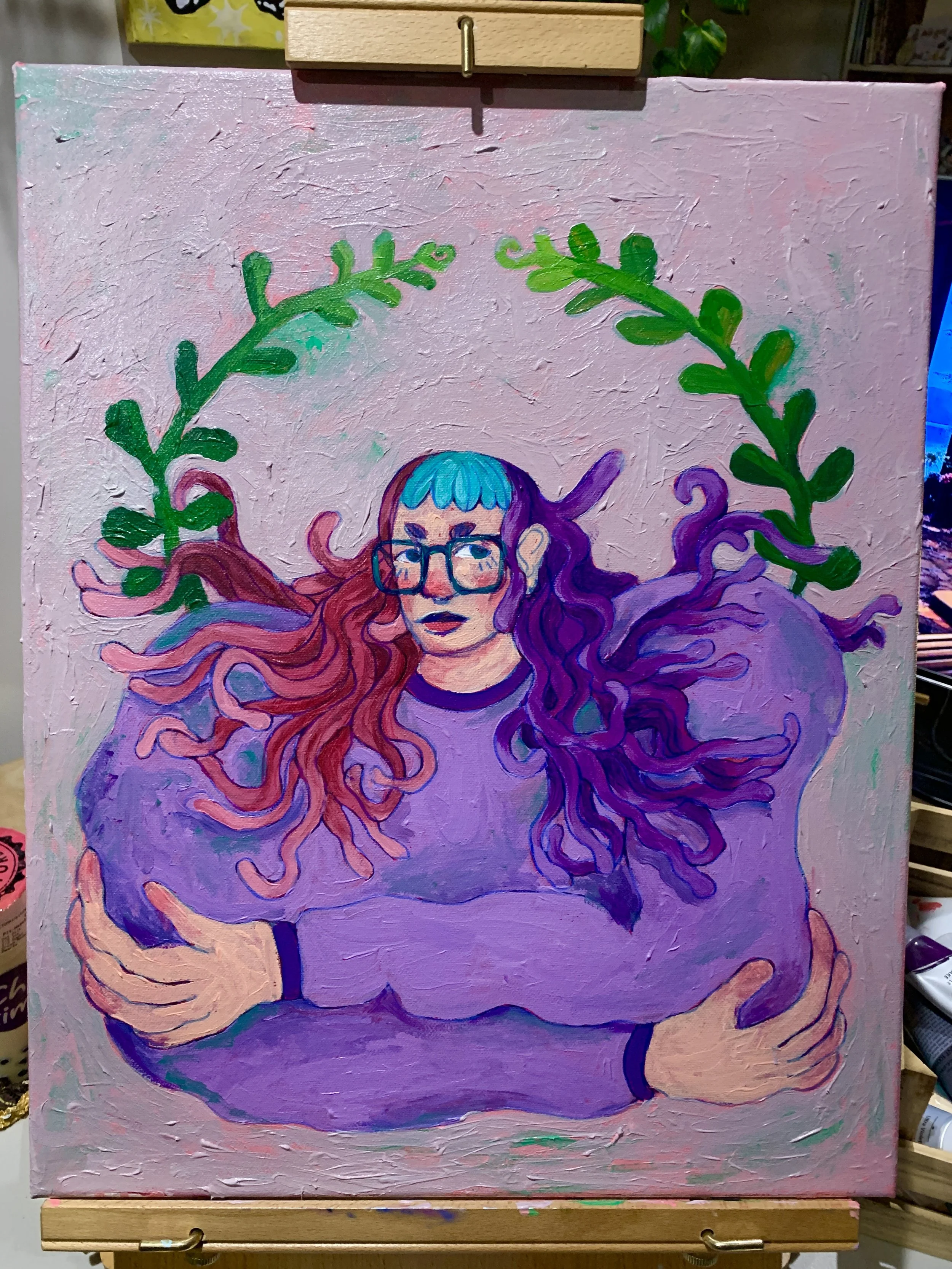 A painting of a woman with long, colorful, flowing hair in shades of pink, purple, and orange. She has glasses and an expressionless face. The background is pink with green leafy branches arching over her head.
