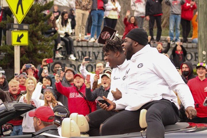 University of Georgia defensive tackles Jordan Davis (left) and Devonte Wyatt (right) sit in the back of a car during the UGA College Football Playoff National Championship Parade on Jan. 15. UGA alumna Kati Weller attended the UGA vs. University of 