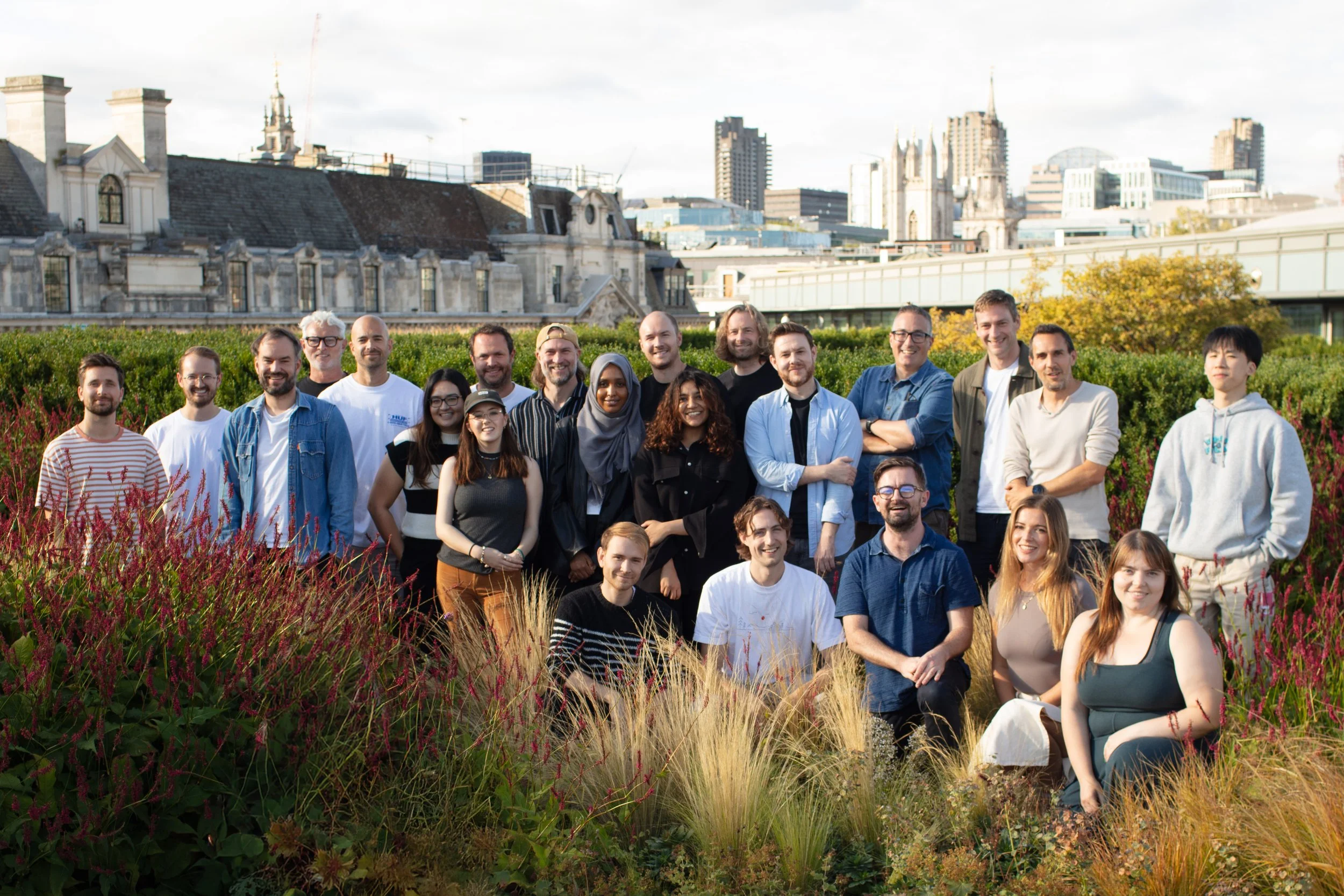 Group of people outdoors in a garden with city buildings in the background. Iris Worldwide.