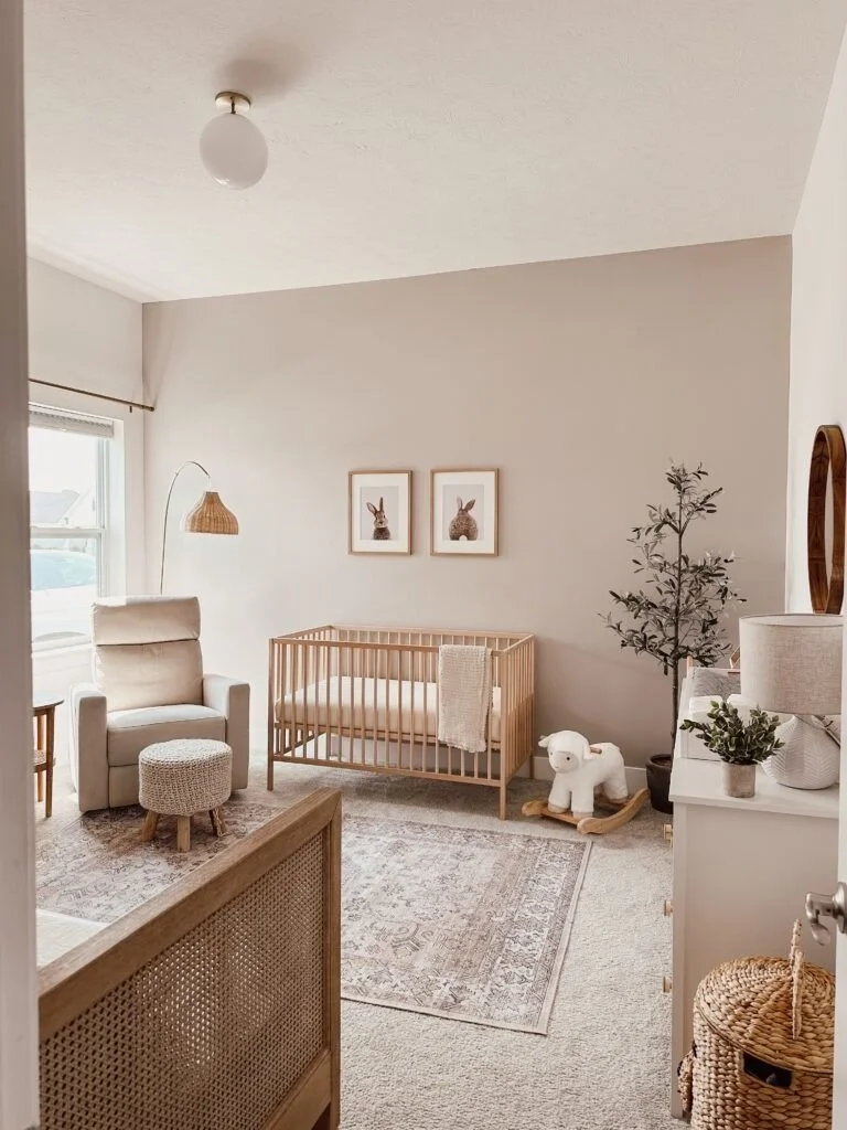 “A beige nursery with a crib, dresser, and rocking chair