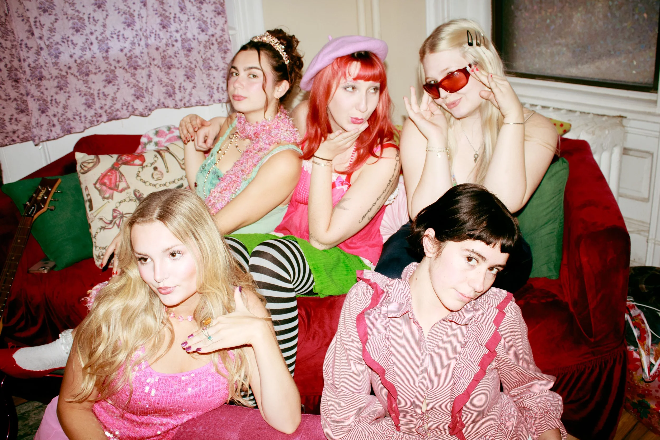  Lizzie McGuire, Strawberry Shortcake, Junie B. Jones, Pinkalicious, and Fancy Nancy posing together playfully on a couch. 