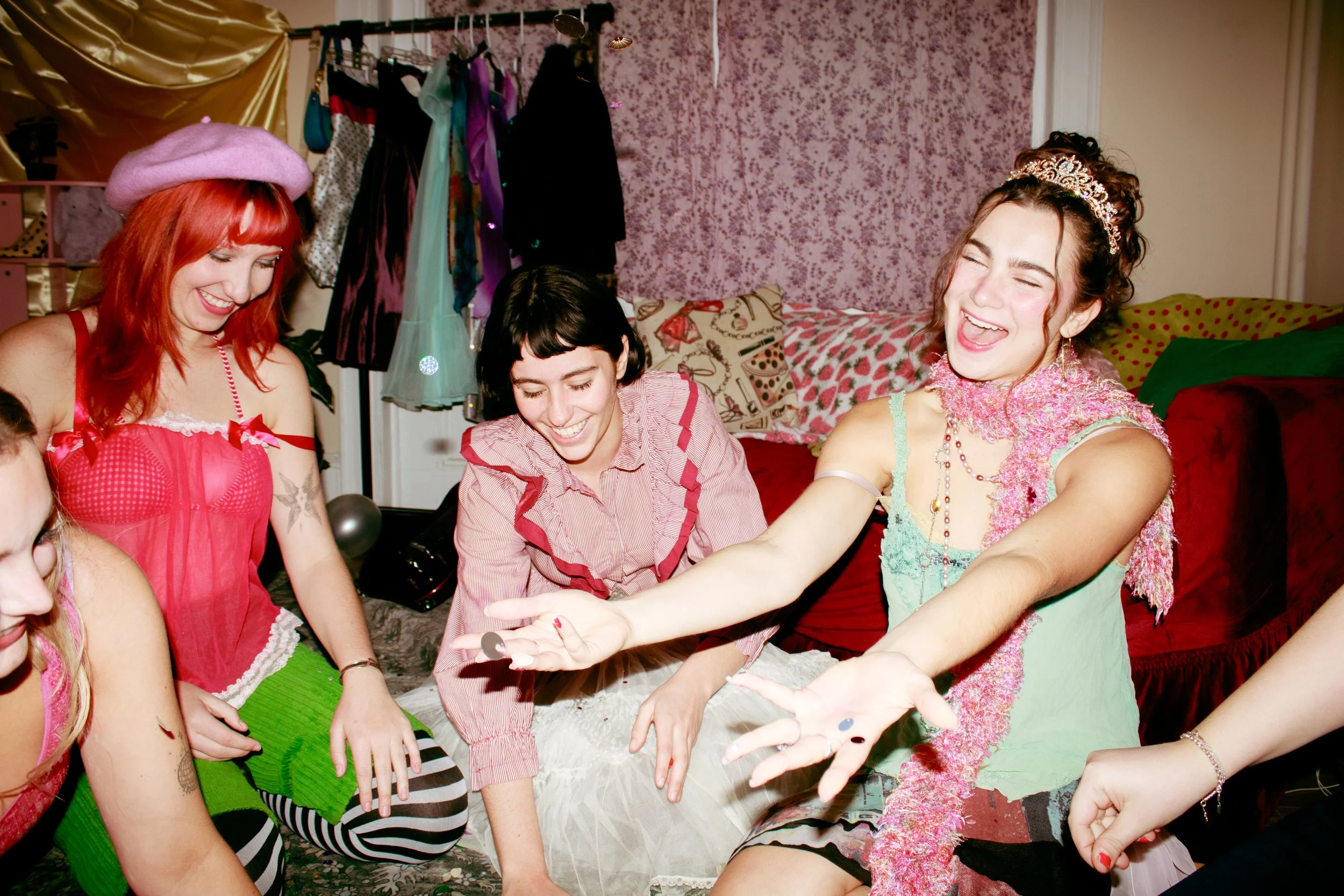  Girl throwing sequins and glitter in the air while other friends laugh. 
