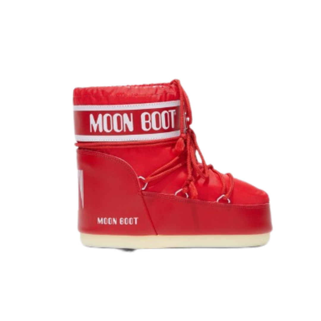  Bright red Moon Boot snow boot with white “MOON BOOT” logo strap and thick cream-colored sole.&nbsp; 