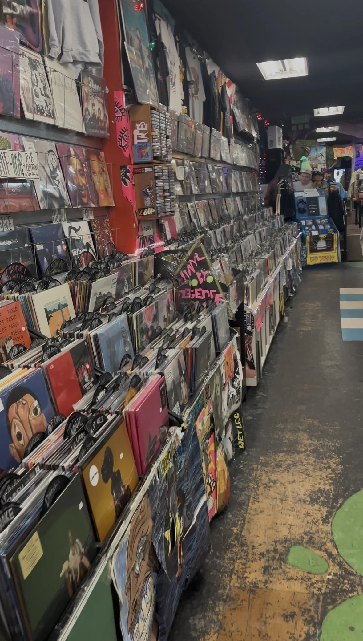 Long aisle of vinyl records lining the wall inside Repo Records 