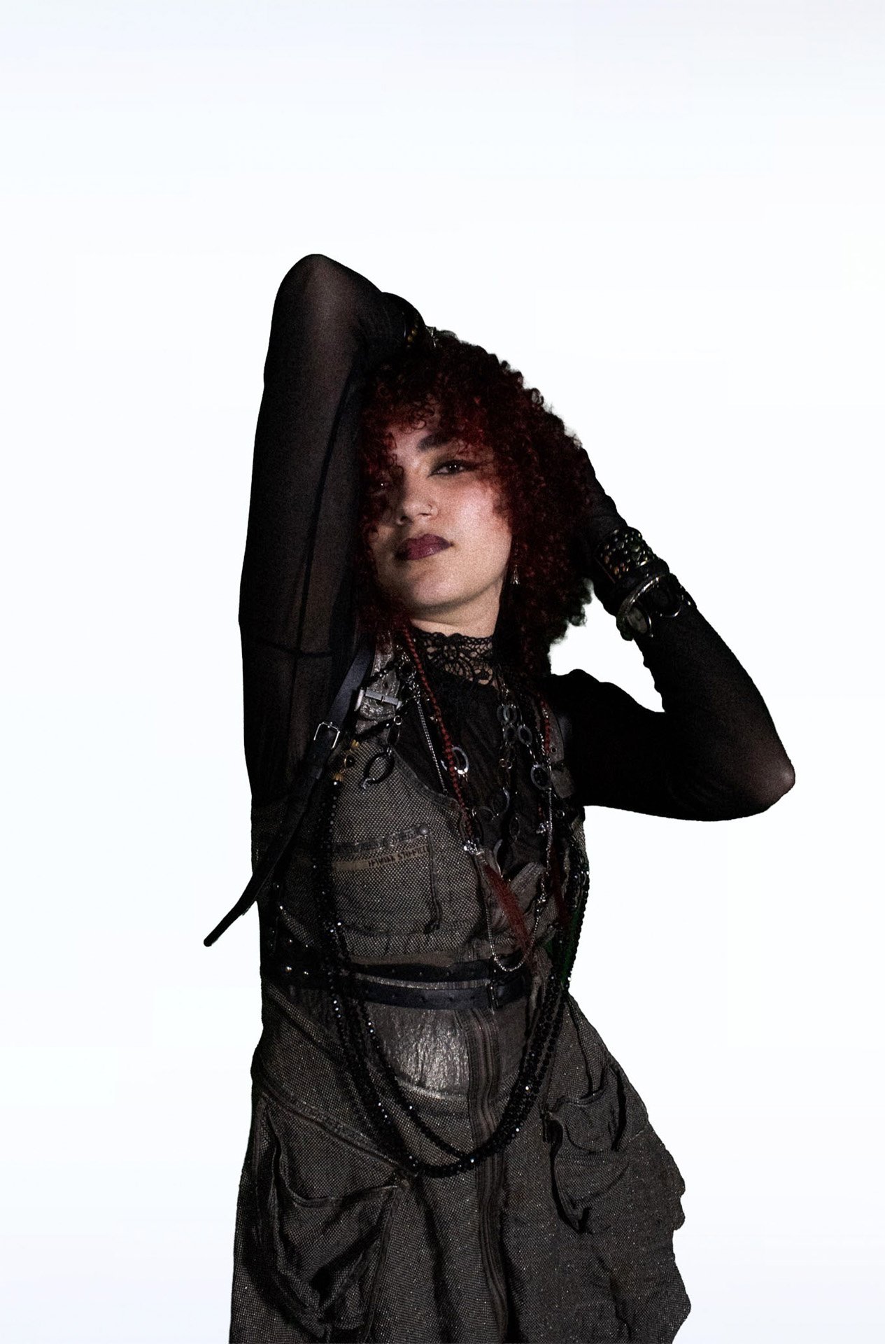  Person sitting sideways in black mesh and platform boots.   