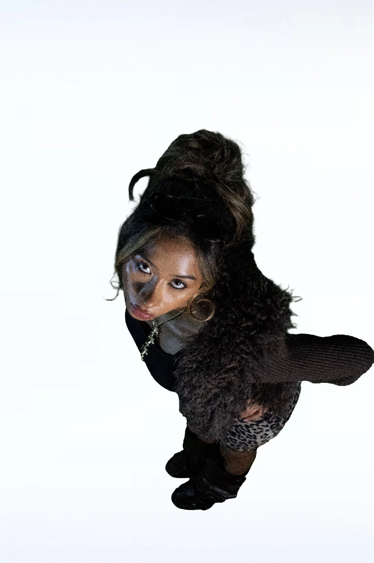  Person looking up wearing a fur-trim sweater and leopard skirt.   