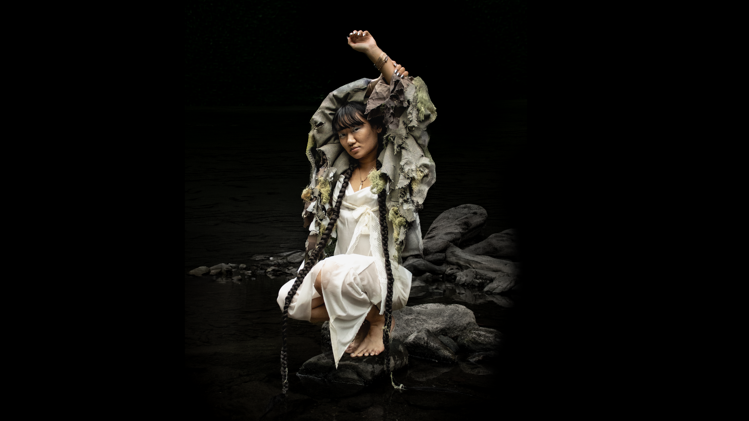 Model in wet silk dress and green moss covered blazer in rocky terrain - Somaesthetics Emma Detwiler Photographer