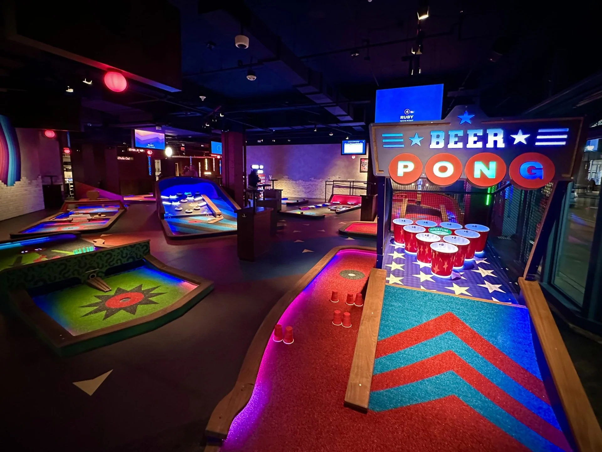 A high-energy, modern indoor mini-golf course featuring neon-lit tracks and tech-infused obstacles.
