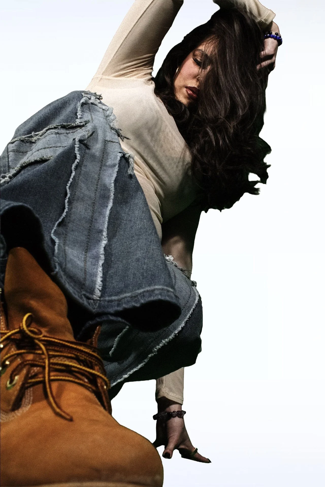 Person in a fur coat making a playful hand gesture against a white background.